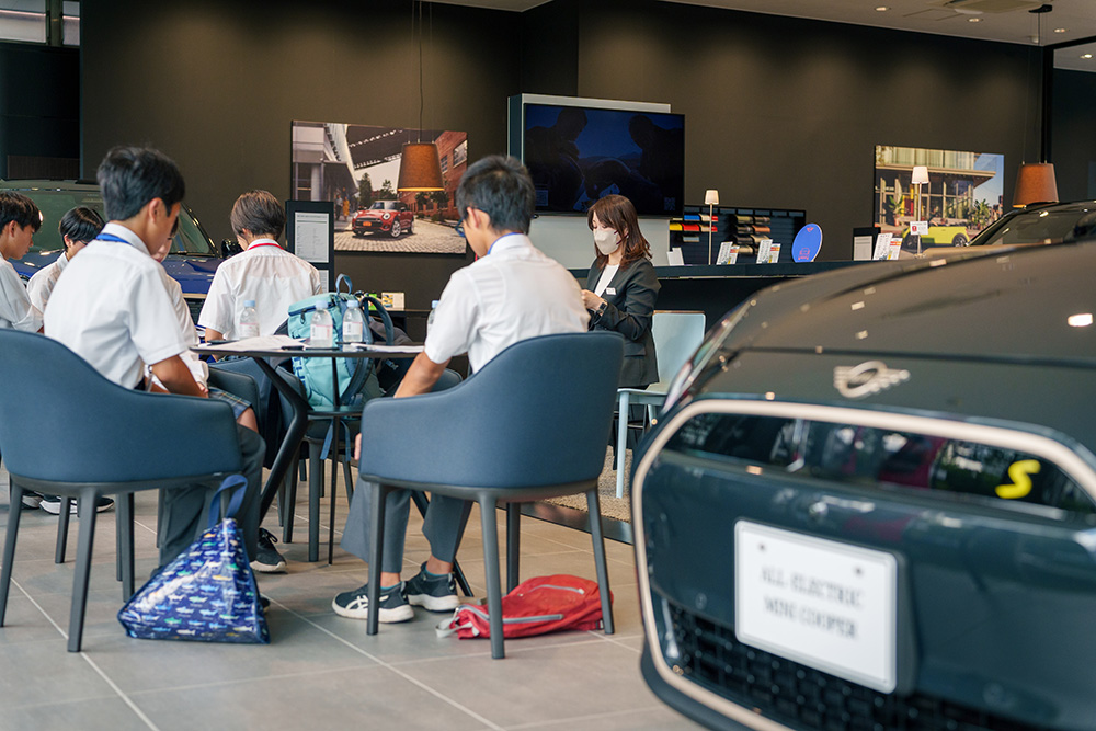 MINI の車両を使って営業体験の成果を発表する中学生の様子